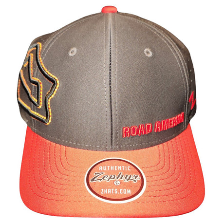 The Antonio Hat is dark gray with a red visor. The Road America track outline is embroidered in black, red and yellow over the right ear on the side panels. The back is perforated for breathability. Road America is embroidered on front left panel.